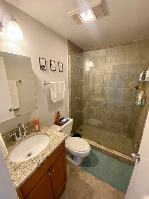 A bathroom with a toilet, sink, and shower.