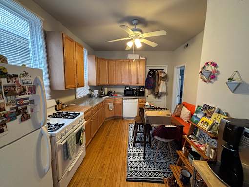 A kitchen with wooden floors and a white refrigerator.