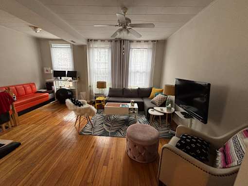 A living room with a red couch, a television, and a dog.