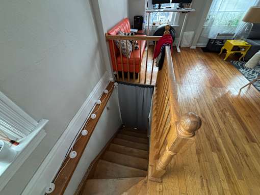 A white staircase with wooden steps and handrail.