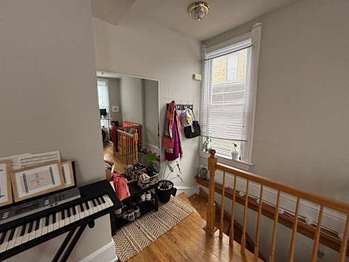 A room with a piano and a mirror on the wall.