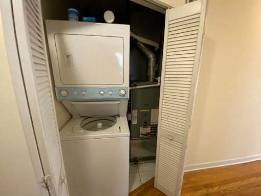 A white washing machine is installed in a small room.