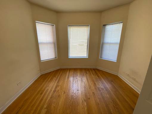 A room with wooden floors and two windows.