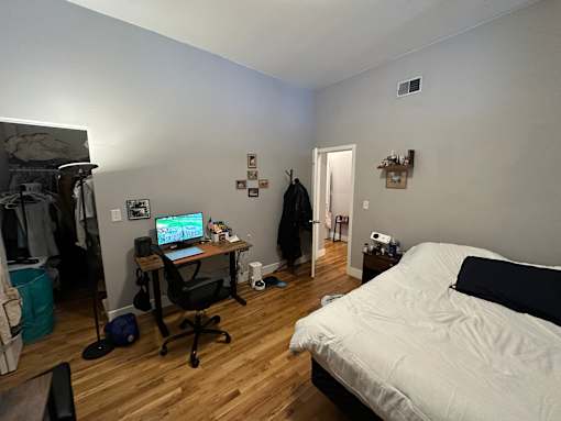 A room with a bed, desk, and chair.