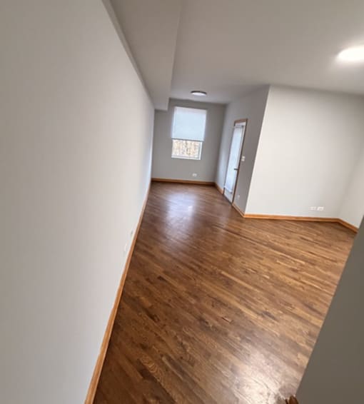 A room with wooden flooring and a window.
