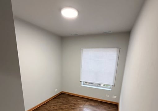 A room with a window and wooden flooring.