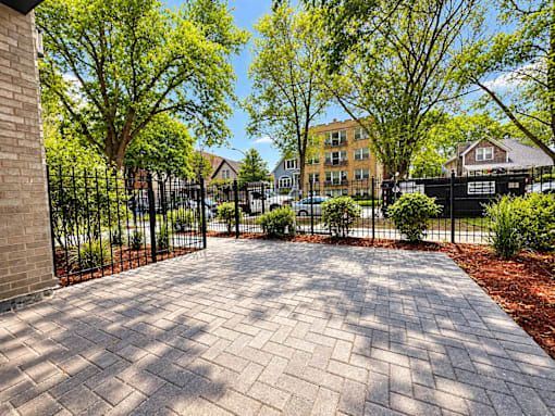 A brick pathway leads to a gated entrance.