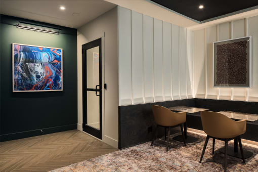 a dining room with a table and chairs and a painting on the wall
