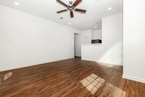 a living room with hardwood floors and a ceiling fan