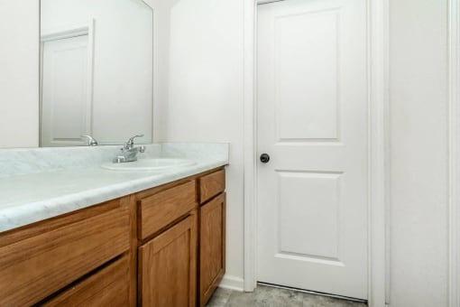 a bathroom with a sink and a mirror and a door