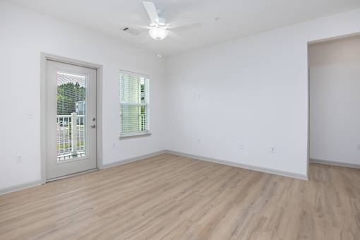 A room with a wooden floor and a ceiling fan.