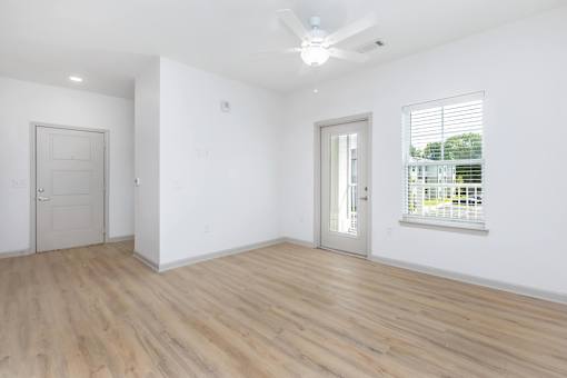 A room with a ceiling fan and two doors.