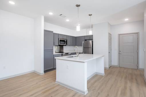 A kitchen with a white island and stainless steel appliances.