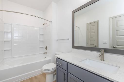 A white bathroom with a toilet, sink, and bathtub.