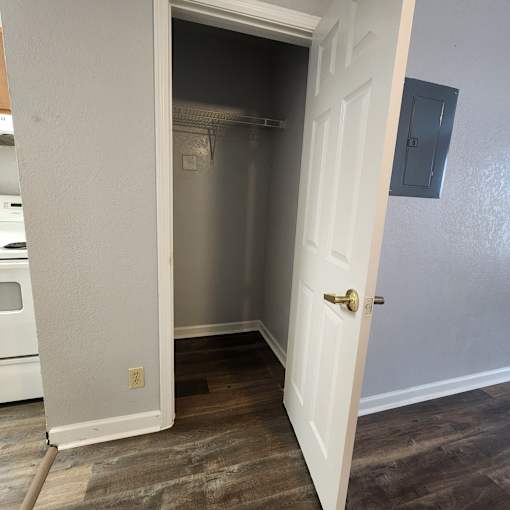 A white door is open to a small kitchen.