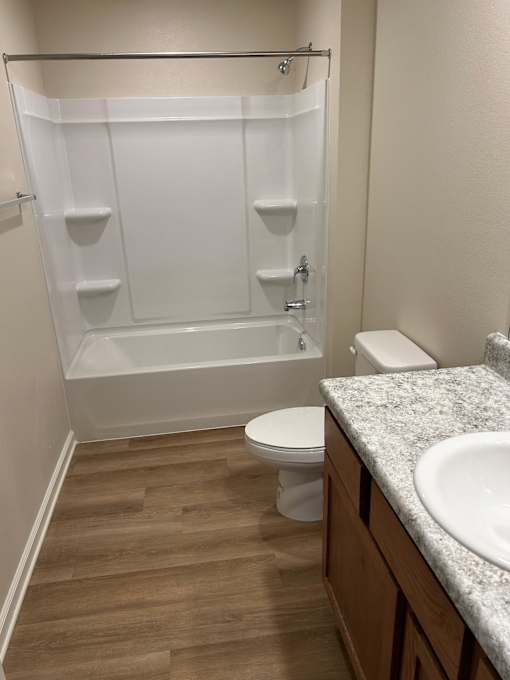 A white toilet sits next to a sink in a bathroom.