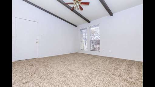 A room with a ceiling fan and a window.
