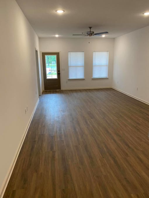 an empty living room with a hard wood floor