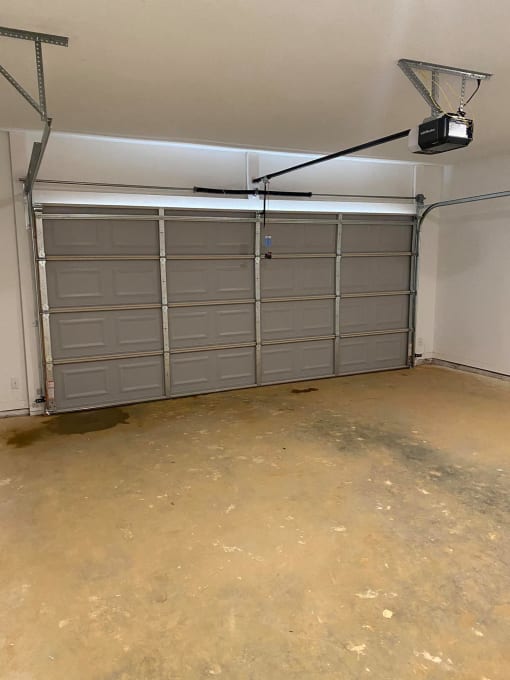 a garage with white doors and a tv on the ceiling