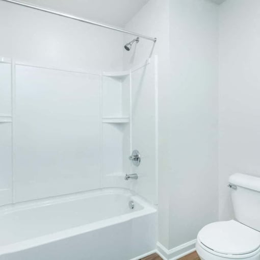 a white bathroom with a tub and a toilet