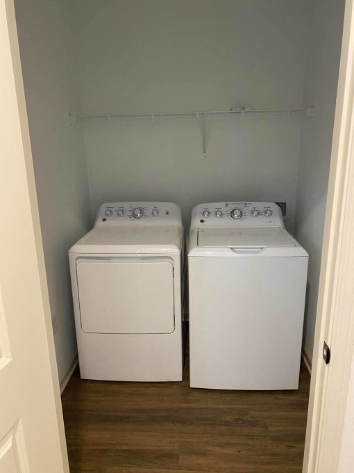 a washer and dryer in a room with a wooden floor