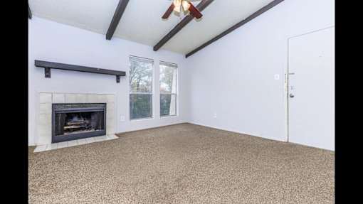 A room with a fireplace and a ceiling fan.
