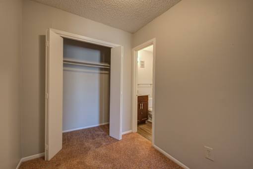 A room with a carpeted floor and a white door.