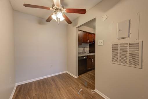 A room with a ceiling fan and a wall-mounted air conditioner unit.