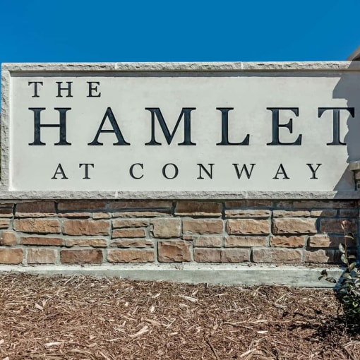 a sign for the hamlet atcc on top of a brick wall
