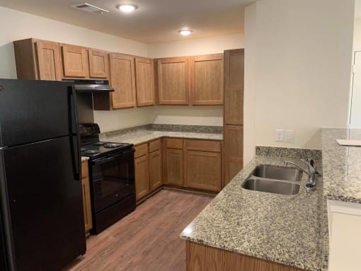 a kitchen with granite counter tops and wooden cabinets