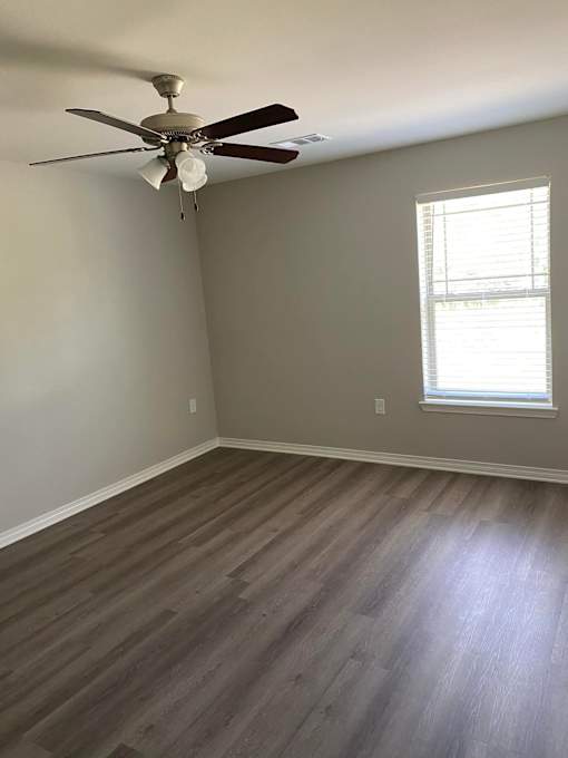 A room with a ceiling fan and a window.
