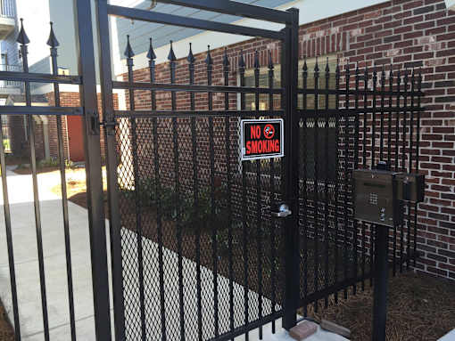 A black gate with a no smoking sign attached to it.