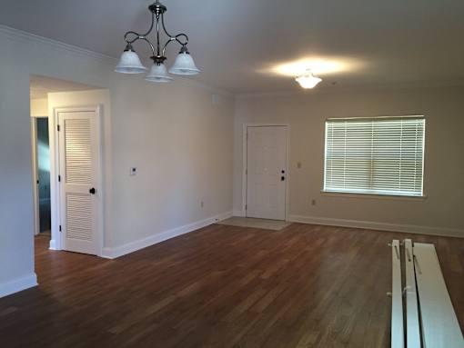 A room with wooden floors and a chandelier.