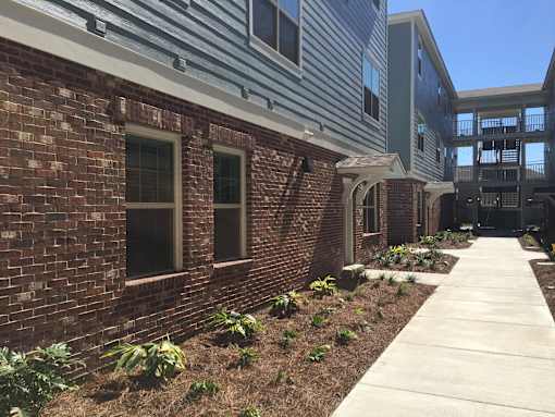 A brick building with a walkway in front.