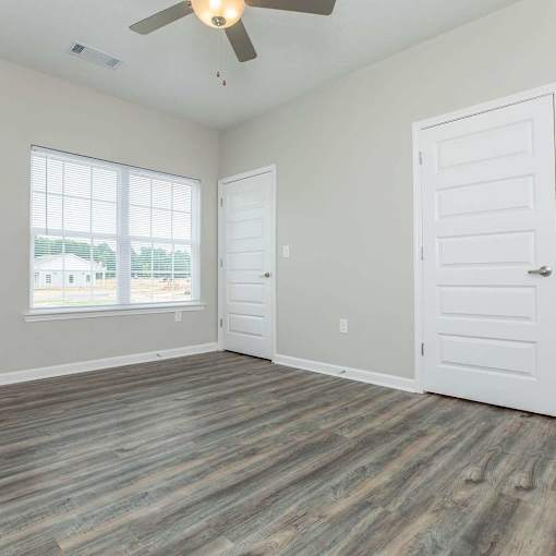 A room with a ceiling fan and two doors.