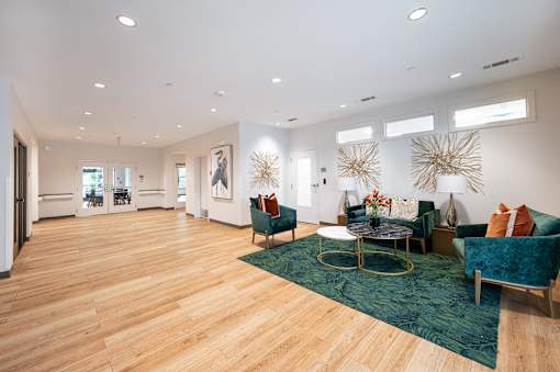 A spacious living room with a green rug and a coffee table.