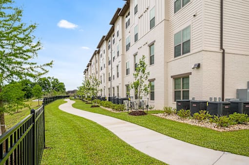 A long building with a green lawn in front.