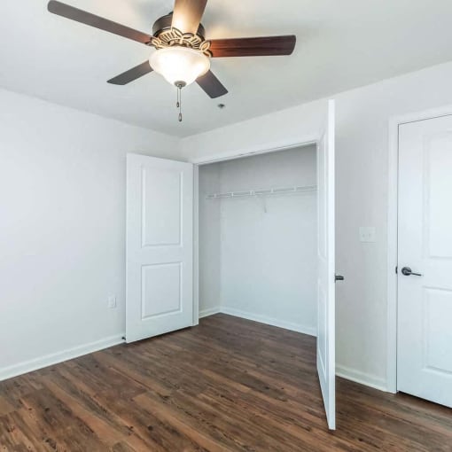 a bedroom with a ceiling fan and a closet
