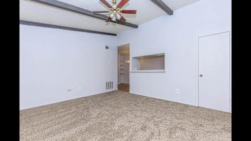 A room with a ceiling fan and a door on the right side.