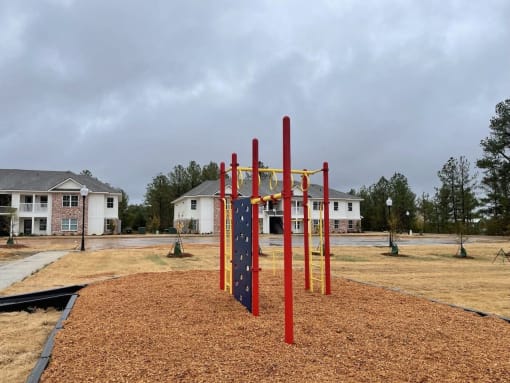 a playground in a park with houses in the background