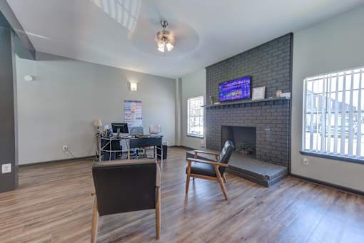 A living room with a fireplace and a TV mounted above it.