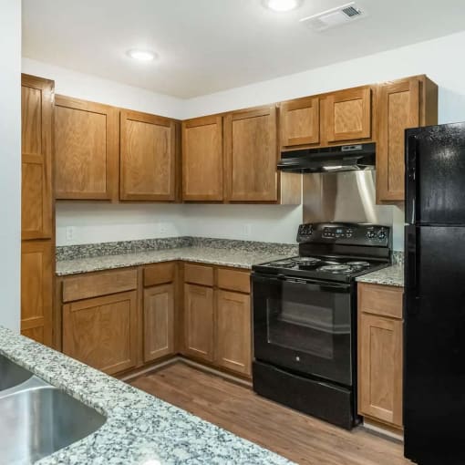 a kitchen with black appliances and wooden cabinets