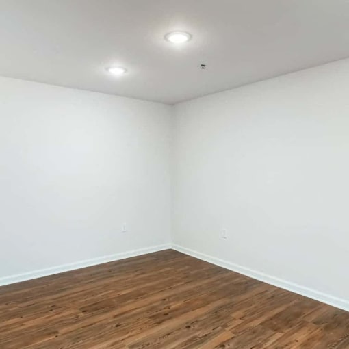 an empty room with white walls and wooden floors