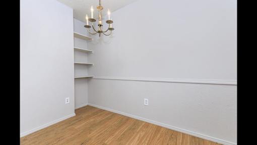 A room with a wooden floor and a chandelier.