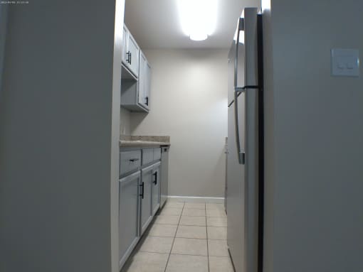 a kitchen with white cabinets and a stainless steel refrigerator