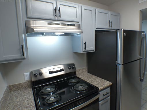 a kitchen with white cabinets and a stove and refrigerator