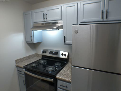 a kitchen with white cabinets and a stove and refrigerator