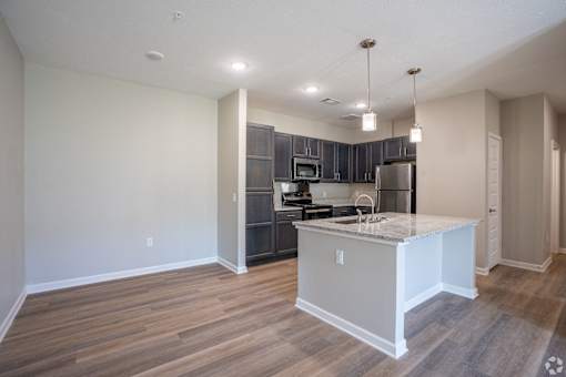 A kitchen with a white island and wooden floors.
