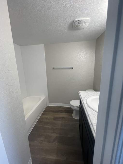 A small bathroom with a toilet, sink, and bathtub.