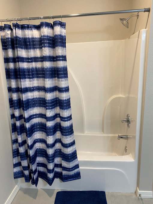 a bathroom with a shower curtain and a bath tub